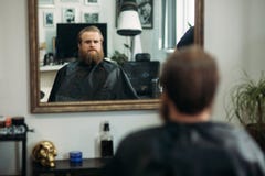 Master cuts hair and beard of men in the barbershop, hairdresser makes hairstyle for a young man stock image Master cuts hair and beard of men in the barbershop, hairdresser makes hairstyle for a young man stock image