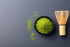 Matcha, green tea powder in black bowl with bamboo whisk on slate background. Top view. Copy space Royalty Free Stock Photos Matcha, green tea powder in black bowl with bamboo whisk on slate background. Top view. Copy space Royalty Free Stock Photos