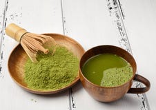 Matchapulver för grönt te i en träbunke med viftar och en matcha för kopp för grönt te arkivbild Matchapulver för grönt te i en träbunke med viftar och en matcha för kopp för grönt te arkivbild