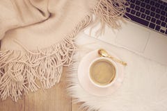 Matins confortables d'hiver Café, ordinateur portable et une écharpe chaude sur un tapis blanc de fourrure sur le plancher photo libre de droits Matins confortables d'hiver Café, ordinateur portable et une écharpe chaude sur un tapis blanc de fourrure sur le plancher photo libre de droits
