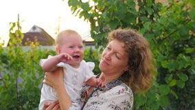 Matriz feliz com bebé O bebê com cara de sorriso está acenando nas mãos da mãe video estoque Matriz feliz com bebé O bebê com cara de sorriso está acenando nas mãos da mãe video estoque