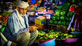 Asian vendor sat by market stall selling food stock photography Asian vendor sat by market stall selling food stock photography