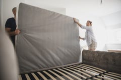 Couple Setting Up Bed Together in New Home Royalty Free Stock Photography Couple Setting Up Bed Together in New Home Royalty Free Stock Photography