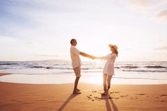 Mature Couple Walking on the Beach at Sunset stock photos Mature Couple Walking on the Beach at Sunset stock photos
