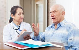 Mature doctor talks with senior man stock photo Mature doctor talks with senior man stock photo