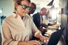 Focused mature designer working with a laptop in an office royalty free stock photography Focused mature designer working with a laptop in an office royalty free stock photography