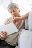 Mature man in sofa websurfing stock photo Mature man in sofa websurfing stock photo