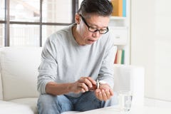 Mature 50s Asian Chinese man eating medicine Stock Photo Mature 50s Asian Chinese man eating medicine Stock Photo
