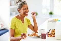 Mature Woman Eating Breakfast At Home stock images Mature Woman Eating Breakfast At Home stock images