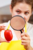 Woman inspecting tomato with magnifying glass. Stock Image Woman inspecting tomato with magnifying glass. Stock Image