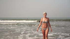 Mature woman senior citizen leads an active lifestyle and swims in the sea