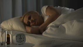Mature woman spending sleepless night at rehabilitation center, feeling pain
