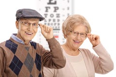 Mayores que sonríen delante de una carta de ojo imagenes de archivo Mayores que sonríen delante de una carta de ojo imagenes de archivo