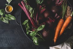 Mazzo di giovani cipolle verdi, barbabietole, carote e basilico su un fondo nero di vecchia annata dei bordi di legno, verdura fr fotografia stock Mazzo di giovani cipolle verdi, barbabietole, carote e basilico su un fondo nero di vecchia annata dei bordi di legno, verdura fr fotografia stock