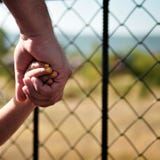 Mała dziewczynka trzyma jej ojca ` s ręki tata trzyma jego córki ` s rękę na spacerze wokoło zoo kwadrat fotografia royalty free Mała dziewczynka trzyma jej ojca ` s ręki tata trzyma jego córki ` s rękę na spacerze wokoło zoo kwadrat fotografia royalty free