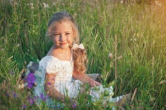 Mała dziewczynka z książką w jej rękach na łące w letnim dniu Zdjęcia Royalty Free Mała dziewczynka z książką w jej rękach na łące w letnim dniu Zdjęcia Royalty Free