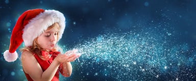 Mała Dziewczynka Z Santa Kapeluszowym Podmuchowym śniegiem zdjęcia stock Mała Dziewczynka Z Santa Kapeluszowym Podmuchowym śniegiem zdjęcia stock