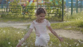 Mały kędzierzawy, dziewczyna więcej podmuchowy dandelion i mała dziewczynka bawić się z kwiatów dandelions wewnątrz zbiory wideo Mały kędzierzawy, dziewczyna więcej podmuchowy dandelion i mała dziewczynka bawić się z kwiatów dandelions wewnątrz zbiory wideo