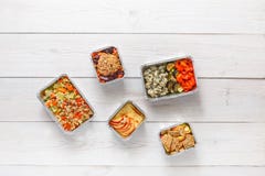 Daily meals delivery in foil containers top view on white wood. royalty free stock photography Daily meals delivery in foil containers top view on white wood. royalty free stock photography