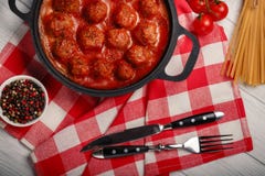 Meatballs in tomato sauce with spices in a frying pan on a white wooden board royalty free stock image Meatballs in tomato sauce with spices in a frying pan on a white wooden board royalty free stock image