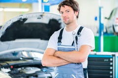 Meccanico che lavora nell'officina dell'automobile fotografia stock libera da diritti Meccanico che lavora nell'officina dell'automobile fotografia stock libera da diritti
