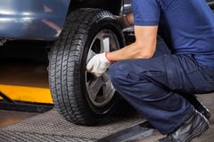 Mechanic Fixing Car Tire At Repair Shop Stock Image Mechanic Fixing Car Tire At Repair Shop Stock Image
