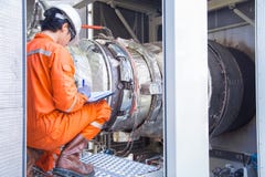 Mechanical engineering inspector checking gas turbine engine inside package enclosure . royalty free stock photography Mechanical engineering inspector checking gas turbine engine inside package enclosure . royalty free stock photography