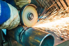 Mechanik czyści spawającego szew na sekcji stalowy pypeć fotografia stock Mechanik czyści spawającego szew na sekcji stalowy pypeć fotografia stock