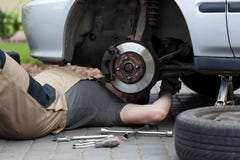 Mechanik naprawia samochodowego koło fotografia stock Mechanik naprawia samochodowego koło fotografia stock