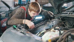 Mechanik sprawdza automobilowego silnika i naprawia, samochód naprawa, pracuje w warsztacie pod kapiszonem, przegląd, zbiory wideo Mechanik sprawdza automobilowego silnika i naprawia, samochód naprawa, pracuje w warsztacie pod kapiszonem, przegląd, zbiory wideo