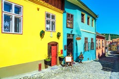 Medeltida saxon gata med färgrika byggnader i Sighisoara, Transylvania, Rumänien royaltyfria bilder Medeltida saxon gata med färgrika byggnader i Sighisoara, Transylvania, Rumänien royaltyfria bilder