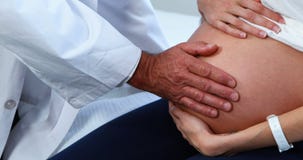 Mediados de sección del vientre conmovedor de la mujer embarazada del doctor en sala metrajes Mediados de sección del vientre conmovedor de la mujer embarazada del doctor en sala metrajes