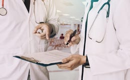 Medical colleagues holding clipboard with paper and working together in doctors office stock images Medical colleagues holding clipboard with paper and working together in doctors office stock images