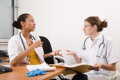 Medical discussion. Two young medical students discussing a case together Medical discussion. Two young medical students discussing a case together