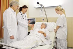 Medici del paziente del reparto di ospedale immagini stock libere da diritti Medici del paziente del reparto di ospedale immagini stock libere da diritti