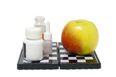 Medicina e una mela su una scacchiera Immagini Stock Medicina e una mela su una scacchiera Immagini Stock