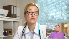 Medicina em linha Mulher idosa que consulta com seu doutor que usa o bate-papo video em casa video estoque Medicina em linha Mulher idosa que consulta com seu doutor que usa o bate-papo video em casa video estoque