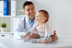Happy doctor or pediatrician with baby at clinic