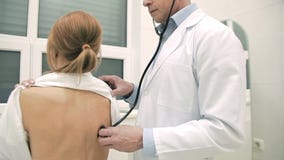 Medico che controlla i polmoni del paziente facendo uso dello stetoscopio archivi video Medico che controlla i polmoni del paziente facendo uso dello stetoscopio archivi video