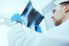 Medico che controlla i risultati dei raggi X fotografie stock Medico che controlla i risultati dei raggi X fotografie stock
