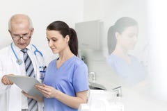 Medico che discute con l'infermiere sopra la lavagna per appunti alla clinica dentaria fotografia stock Medico che discute con l'infermiere sopra la lavagna per appunti alla clinica dentaria fotografia stock