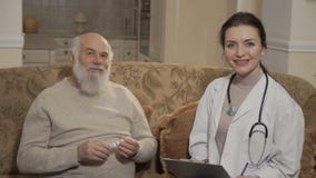 Medico e le vecchie manifestazioni pazienti sfoglia fino alla macchina fotografica stock footage Medico e le vecchie manifestazioni pazienti sfoglia fino alla macchina fotografica stock footage