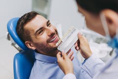 Medico e paziente che scelgono gli impianti del dente fotografia stock Medico e paziente che scelgono gli impianti del dente fotografia stock