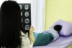 Medico femminile di retrovisione Vedi che ragazzo asiatico della lastra radioscopica è malata con influenza, sonno nel letto di o fotografie stock libere da diritti Medico femminile di retrovisione Vedi che ragazzo asiatico della lastra radioscopica è malata con influenza, sonno nel letto di o fotografie stock libere da diritti
