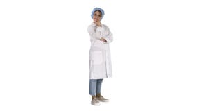 Medico sicuro sorridente della giovane donna che sta con le armi attraversate su fondo bianco fotografie stock Medico sicuro sorridente della giovane donna che sta con le armi attraversate su fondo bianco fotografie stock