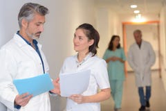 Medics discussing notes in hospital corridor royalty free stock photography Medics discussing notes in hospital corridor royalty free stock photography