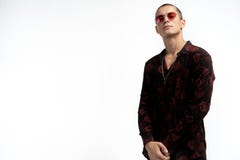 Medio retrato de la longitud del hombre atractivo alegre en vidrios de sol rojos, camisa negra de moda que lleva, mirando la c?ma imagen de archivo Medio retrato de la longitud del hombre atractivo alegre en vidrios de sol rojos, camisa negra de moda que lleva, mirando la c?ma imagen de archivo