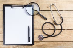 Medische klembord en stethoscoop, vergrootglas, zwarte pen op houten bureauachtergrond Hoogste mening Werkplaats van een arts royalty-vrije stock afbeelding Medische klembord en stethoscoop, vergrootglas, zwarte pen op houten bureauachtergrond Hoogste mening Werkplaats van een arts royalty-vrije stock afbeelding