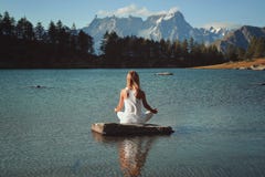 Meditación de la mujer en el lago de la montaña fotografía de archivo libre de regalías Meditación de la mujer en el lago de la montaña fotografía de archivo libre de regalías