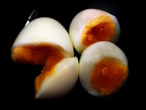 Medium boil egg cut to be half in black cup. royalty free stock image Medium boil egg cut to be half in black cup. royalty free stock image